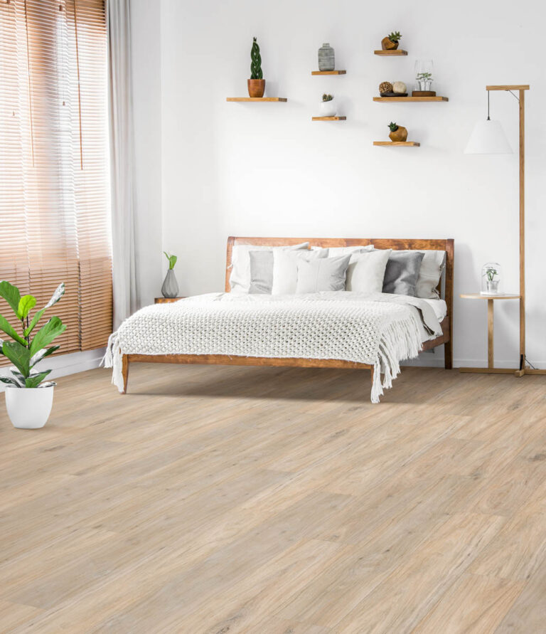 Minimalist bedroom featuring a wooden bed with white bedding, plants, floating shelves with decor, a floor lamp, and natural light streaming through wooden blinds. The floor is light wood.